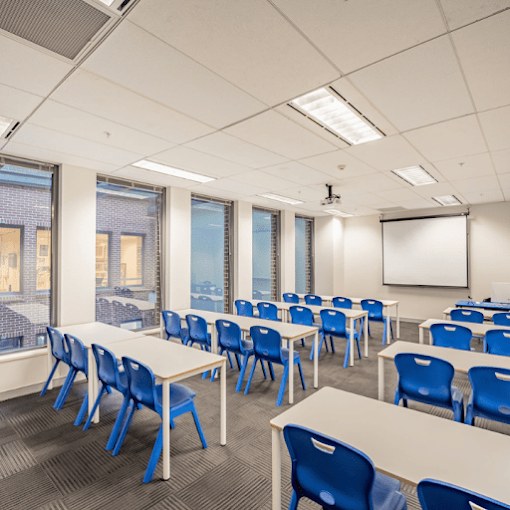 Aula luminosa con proyector en el campus de ACBI
